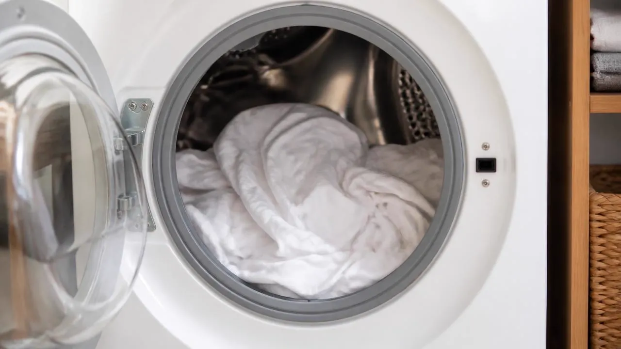 White cotton in a front-loading washer, used for an oxygen bleach soak to remove mildew odor.